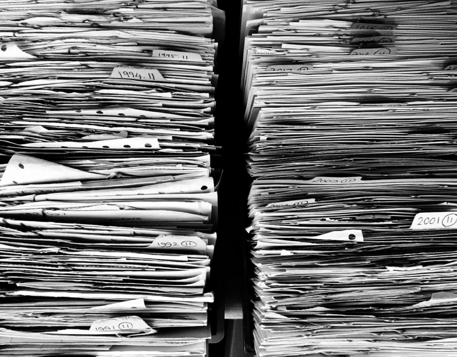 Stacks of archived paper files organized by year